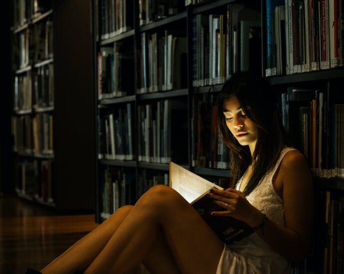 woman leaning on bookshelf