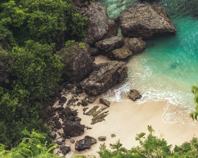 aerial view of seashore near large grey rocks