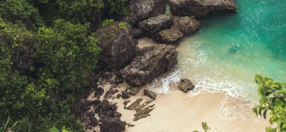 aerial view of seashore near large grey rocks