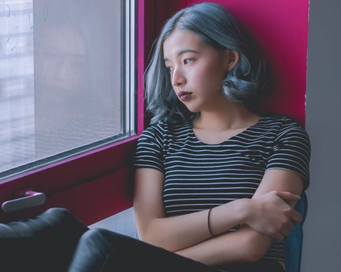 woman in black and white striped shirt while looking out at the window
