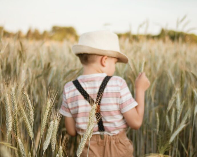 photo of a boy in white trilby hat in wheat field