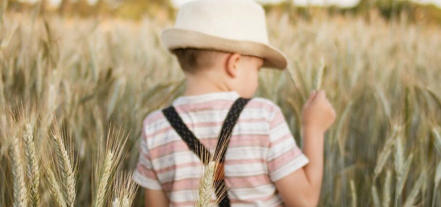 photo of a boy in white trilby hat in wheat field