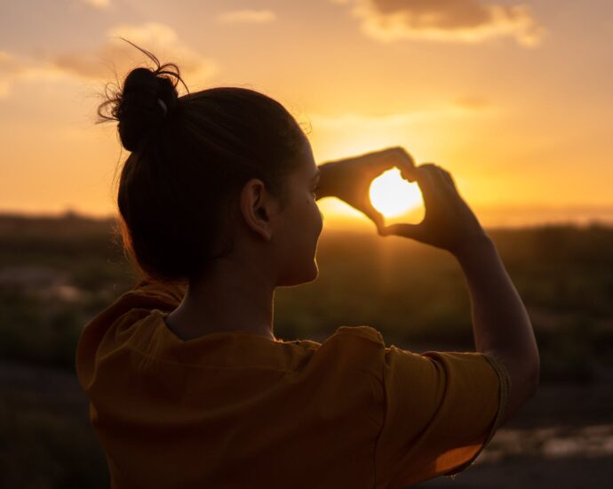 woman doing hand heart sign