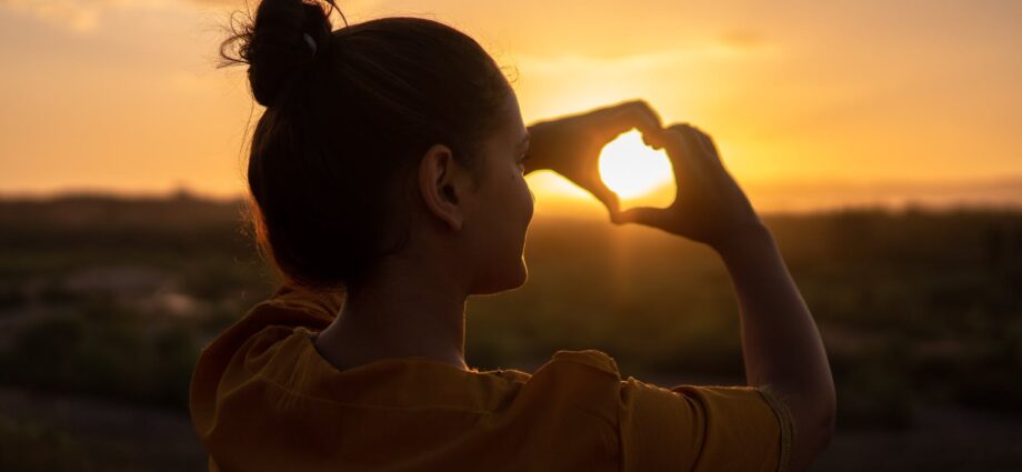 woman doing hand heart sign