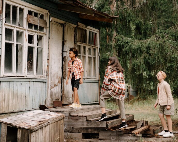 woman in white and red plaid dress shirt standing on brown wooden bridge