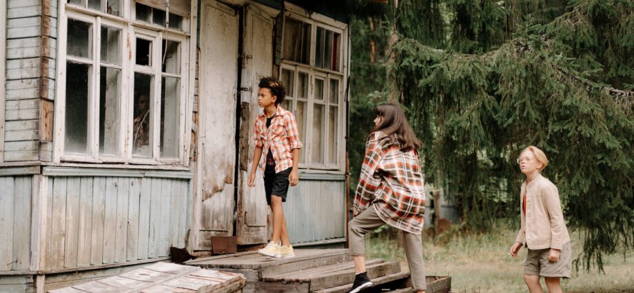 woman in white and red plaid dress shirt standing on brown wooden bridge