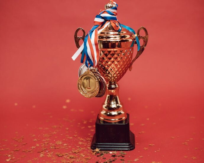 gold and blue trophy on red surface