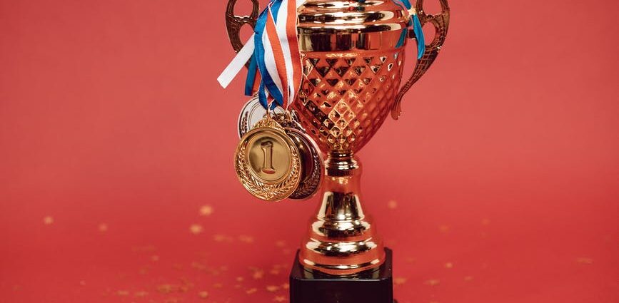 gold and blue trophy on red surface
