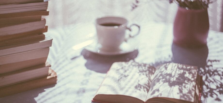 opened book near ceramic mug
